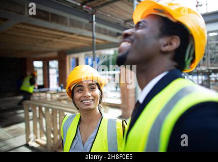 Happy construction workers talking at construction site Stock Photo