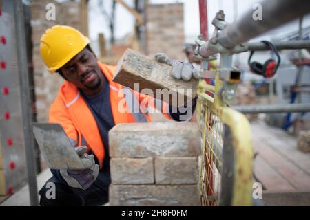 Male construction worker laying bricks at construction site Stock Photo