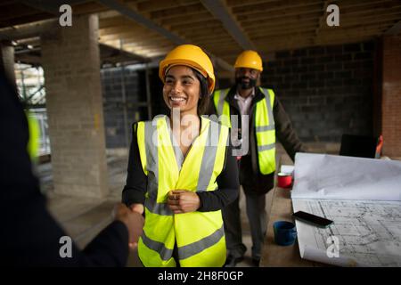 Happy construction workers at construction site Stock Photo