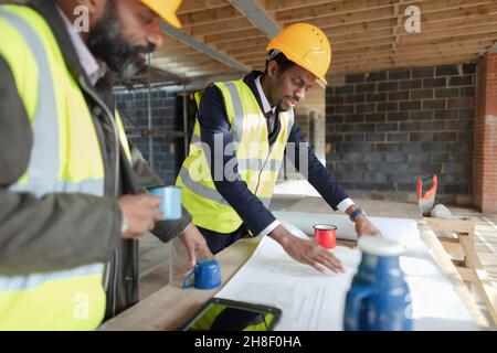 Engineer and architect reviewing blueprints at construction site Stock Photo