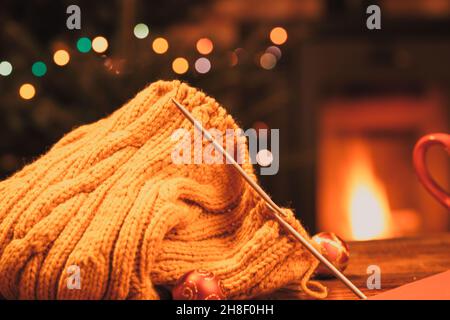 knitted sweater and fireplace in background cozy Christmas scene Stock Photo