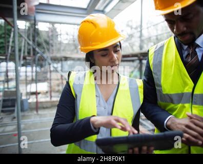 Architects with digital tablet at construction site Stock Photo