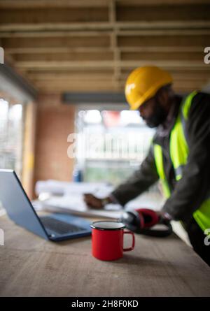 Male architect reviewing blueprints at construction site Stock Photo