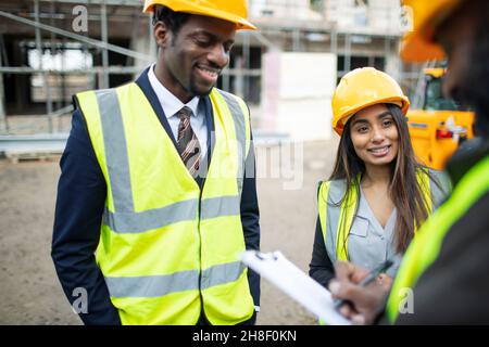 Architects and foreman talking at construction site Stock Photo