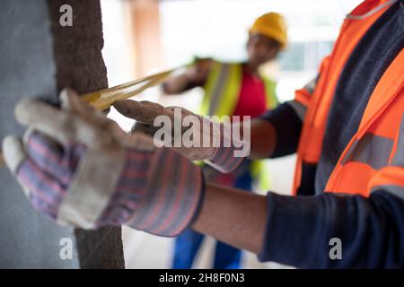 Close up construction workers using tape measure Stock Photo