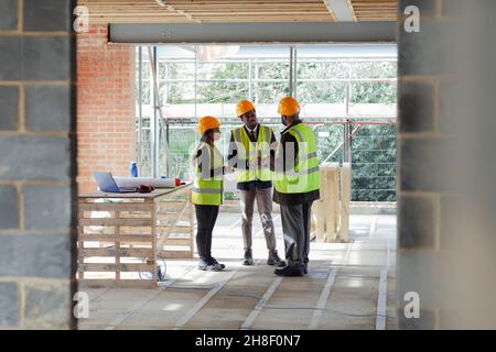 Architects and engineer talking at construction site Stock Photo