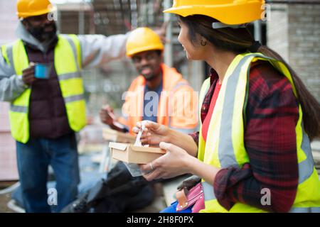 Construction workers eating lunch at construction site Stock Photo