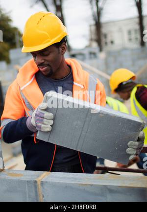 Male construction worker laying cement bricks Stock Photo