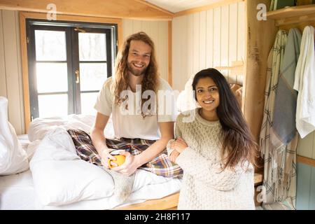 Portrait happy young couple relaxing in cabin Stock Photo