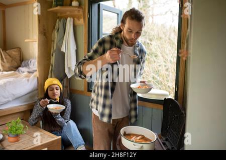 Young couple cooking in tiny cabin rental Stock Photo