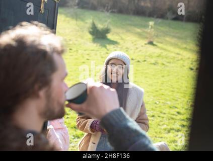 Young couple enjoying coffee at campsite Stock Photo