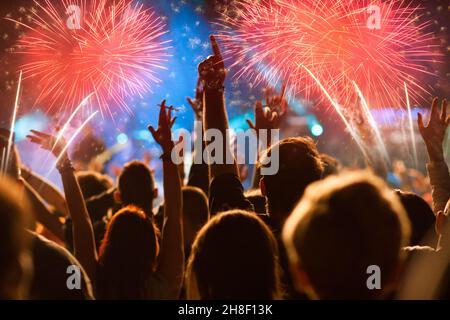 crowd celebrating New Year's Eve watching fireworks Stock Photo
