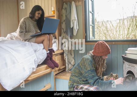 Young couple with laptop in tiny cabin rental Stock Photo