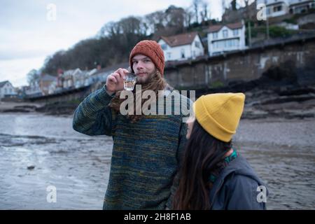 Portrait young couple drinking wine on winter beach Stock Photo