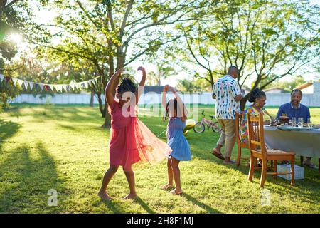 Happy carefree sisters dancing in sunny summer park Stock Photo