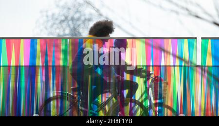 Teenagers riding bicycles on modern bridge Stock Photo