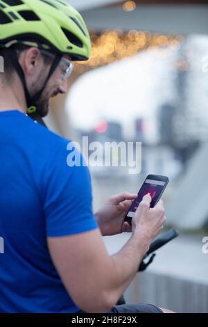 Man in bike helmet using smart phone Stock Photo
