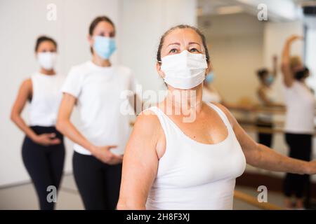 Group of multiethnic female dancers training in masks during COVID-19 pandemic Stock Photo