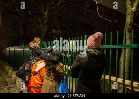 London, England, UK. 29th Nov, 2021. Portobello, London, United Kingdom, evening of 29th November 2021. Residents Gather near the fences surrounding part of Wornington Green Estate to support a group of ecoactivists. Despite a long campaign and petition by ''˜Wornington Trees' - a grassroots community campaigning to oppose the tree felling on Wornington Green by Catalyst and RBKC Council - developers chopped a large part of the mature trees of the estate. Locals declare they repeatedly complained 'the lack of meaningful consultation with residents. Regeneration should be env Stock Photo