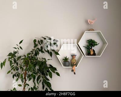 Decorative wooden, floating, hexagon wall shelves on beige wa Stock Photo