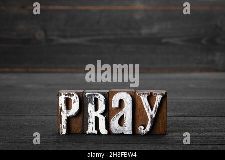 Pray. Faith, religion and the spiritual world concept. Text on a wooden background Stock Photo