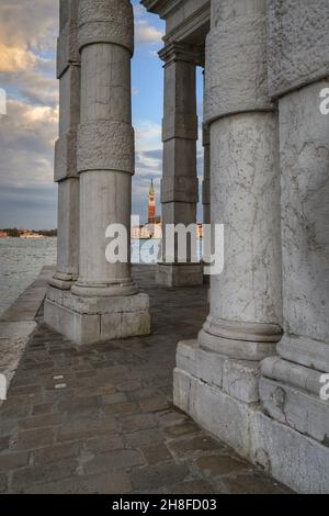 light stone columns at Punta della Dogana in Venice. San Giorgio bell tower on the background Stock Photo