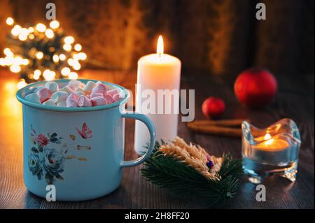 Cup of drink with marshmallows and candles on the table Stock Photo