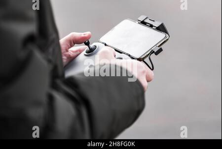 Modern Drone Operator with Smartphone App Controller Close Up. Stock Photo