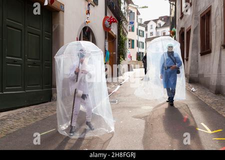 Basel, Switzerland - February 21. Carnival revellers in  makeshift hazmat dress costumes Stock Photo