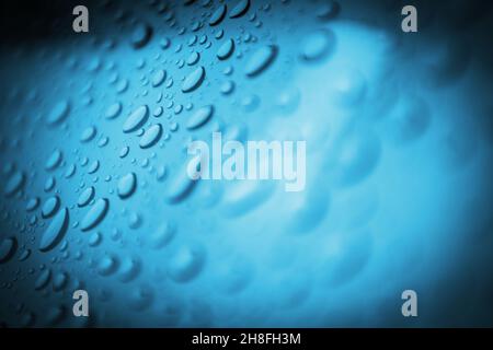 Water Drops on a Blue Piece of Glassy Material Conceptual Background. Stock Photo