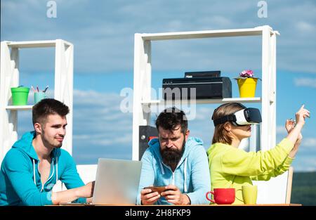 New technology and business concept. Team of three professional male and female designers wearing vr headsets, working with new virtual project in Stock Photo