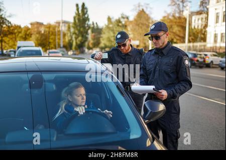 Police patrol checking driver's license of driver Stock Photo