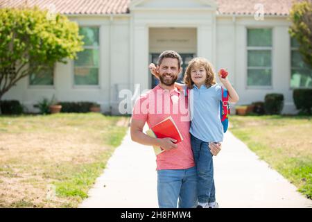 Father and son run with father after come back from school. School, family, education and outdoor concept. Stock Photo