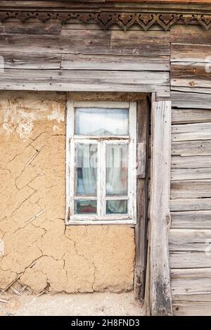 Window with wooden frames in an old wooden house in dilapidated condition Stock Photo