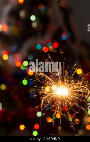 Burning sparklers on a bokeh background of colored lights Stock Photo