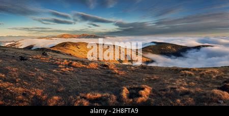 Meadows and Hills in Low Tatra Mountains National Park over clouds, Slovakia landscape in autumn Stock Photo