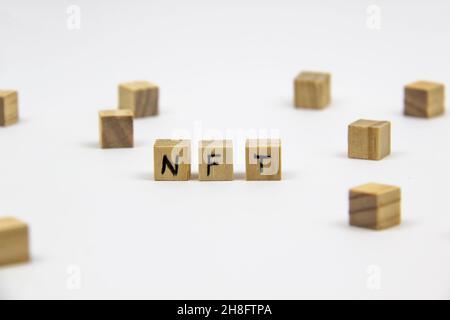 Word NFT (non fungible token) written on the wood cubes on white  background. Non-fungible tokens  concept NFT. Stock Photo