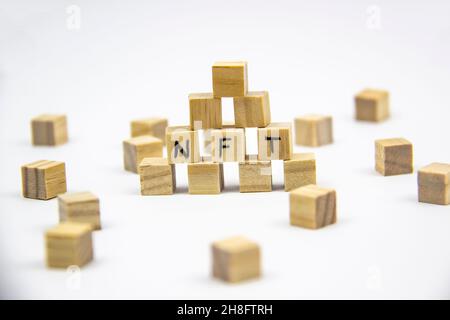 Word NFT (non fungible token) written on the wood cubes on white  background. Non-fungible tokens  concept NFT. Stock Photo