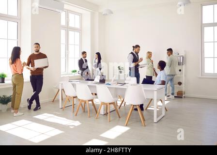 Groups of work colleagues communicate and discuss various work moments in modern workplace. Stock Photo