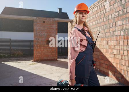 Serious young woman using laser level in her construction job Stock Photo