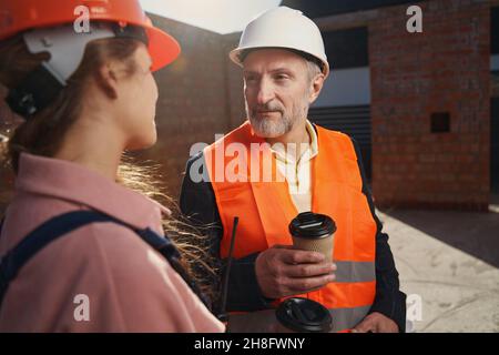 Professional construction workers having a conversation over coffee Stock Photo