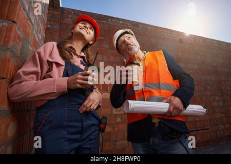 Inspired architects having coffee and looking at the construction site Stock Photo