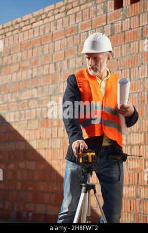 Professional engineer using a laser level in his work Stock Photo