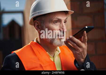 Professional builder having a busy conversation on the phone Stock Photo