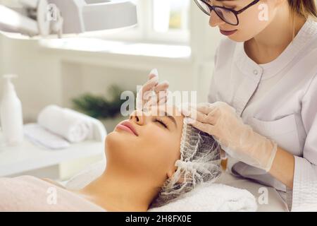 Beautician make facial botox injection to client in saloon Stock Photo