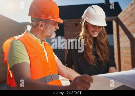 Qualified architects studying the whiteprints of construction object Stock Photo