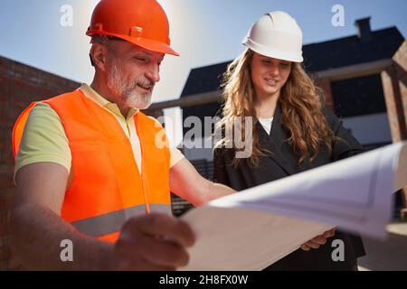 Ambitious builders studying the paper plans of the construction Stock Photo