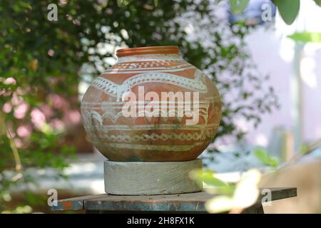 Close-up photo shot of A water pot made of clay kept in the open outside and hand painted white design on it Stock Photo