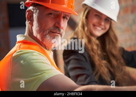Two construction site workers smiling and posing for camera Stock Photo