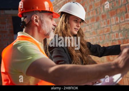 Concetrated construction site workers studying the building plans Stock Photo
